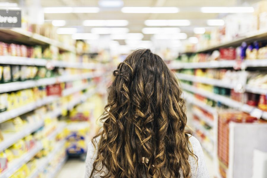 Rückansicht einer Frau, die in einem Supermarkt steht